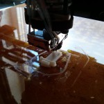 Printing in progress. 3D printer head and half-finished print.