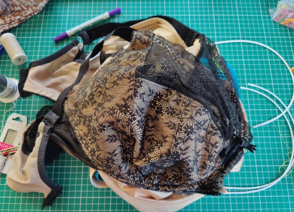 A pile of bras surrounded by underwires and sewing notions.