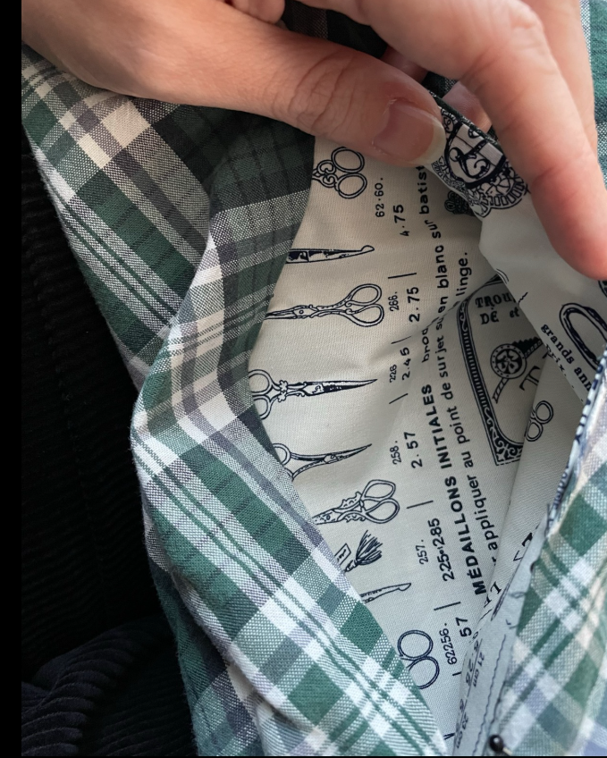 A hand holds open a pocket in the seam of a garment
